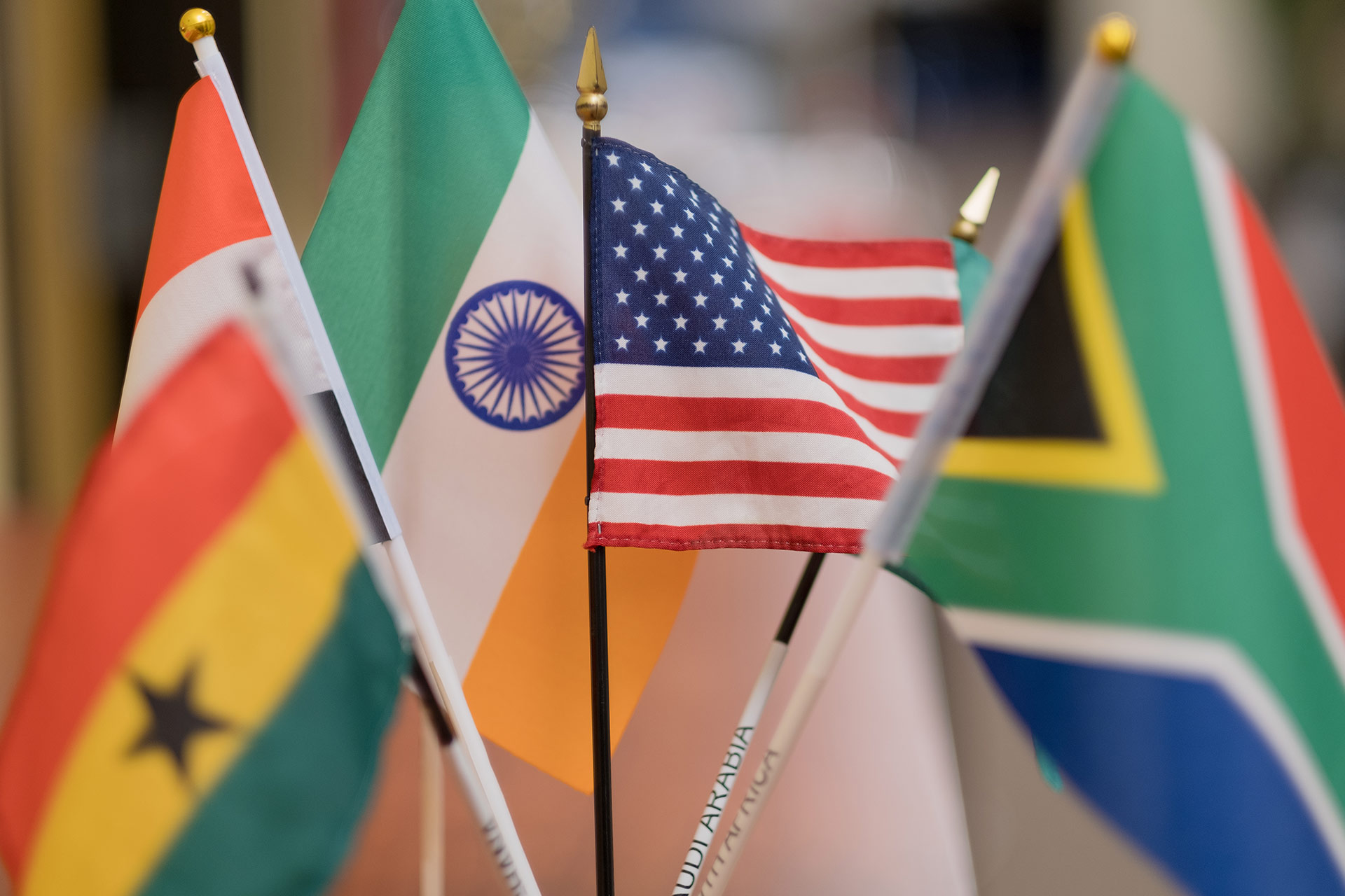 A close-up of several small flags, including those of Ghana, India, the United States, and South Africa, displayed together.