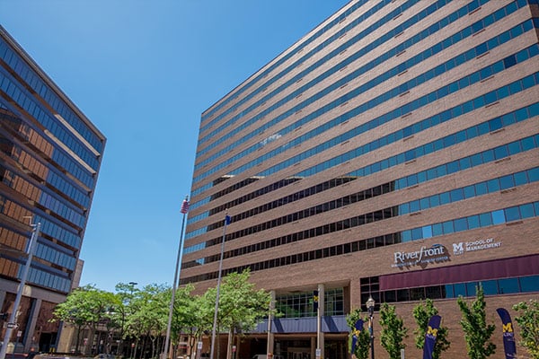 Exterior view of the Riverfront building of the University of Michigan School of Management on a clear day.