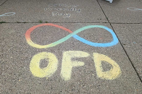 Chalk drawing on pavement featuring an infinity symbol in red, blue, and yellow, with the letters "OFD" below it.