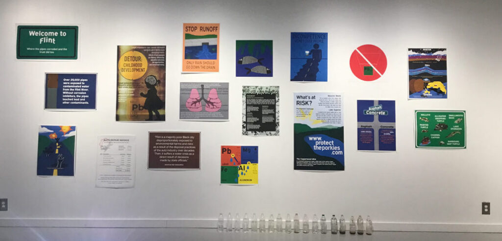 A wall display featuring various informational posters about water safety and environmental issues, with a "Welcome to Flint" sign at the top.