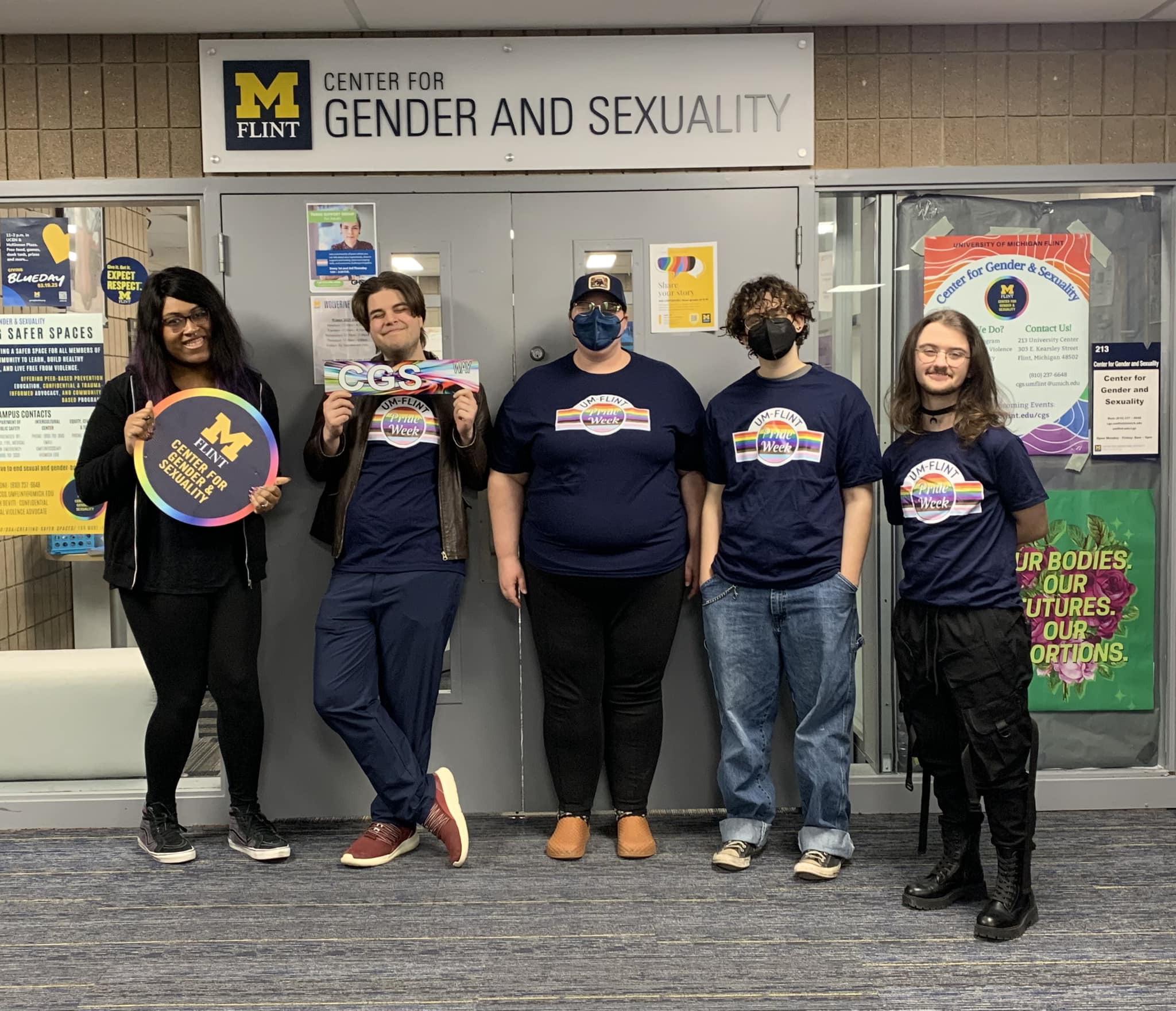 Five people stand in front of a sign for the Center for Gender and Sexuality, holding various promotional materials.