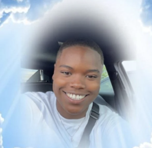A person smiling in a car, surrounded by a soft cloud-like effect.