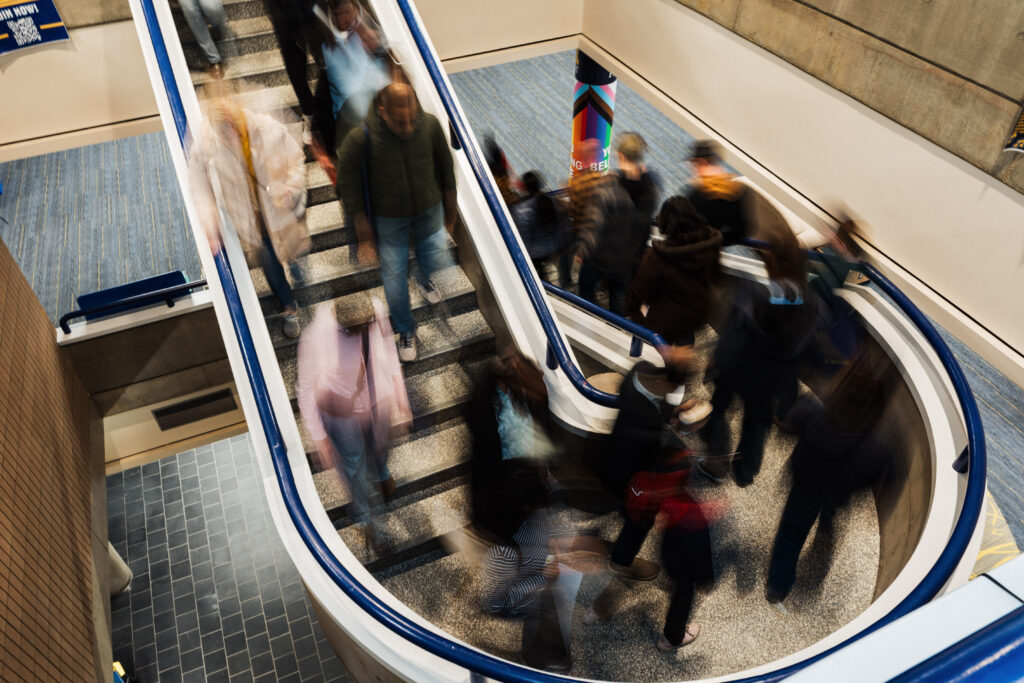 A blurred image of a busy spiral staircase with people moving up and down.