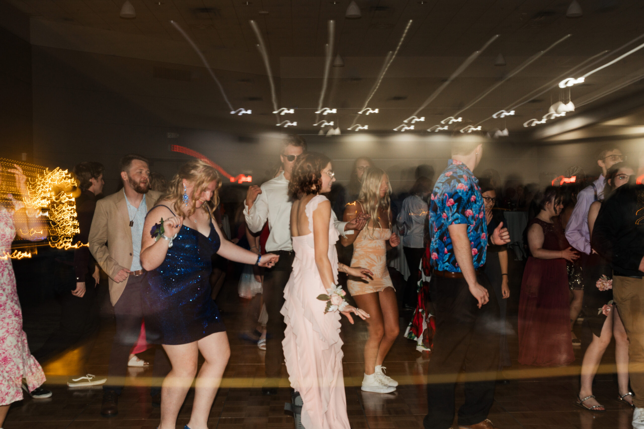 A group of people dancing at a lively event, with motion blur creating a dynamic atmosphere.
