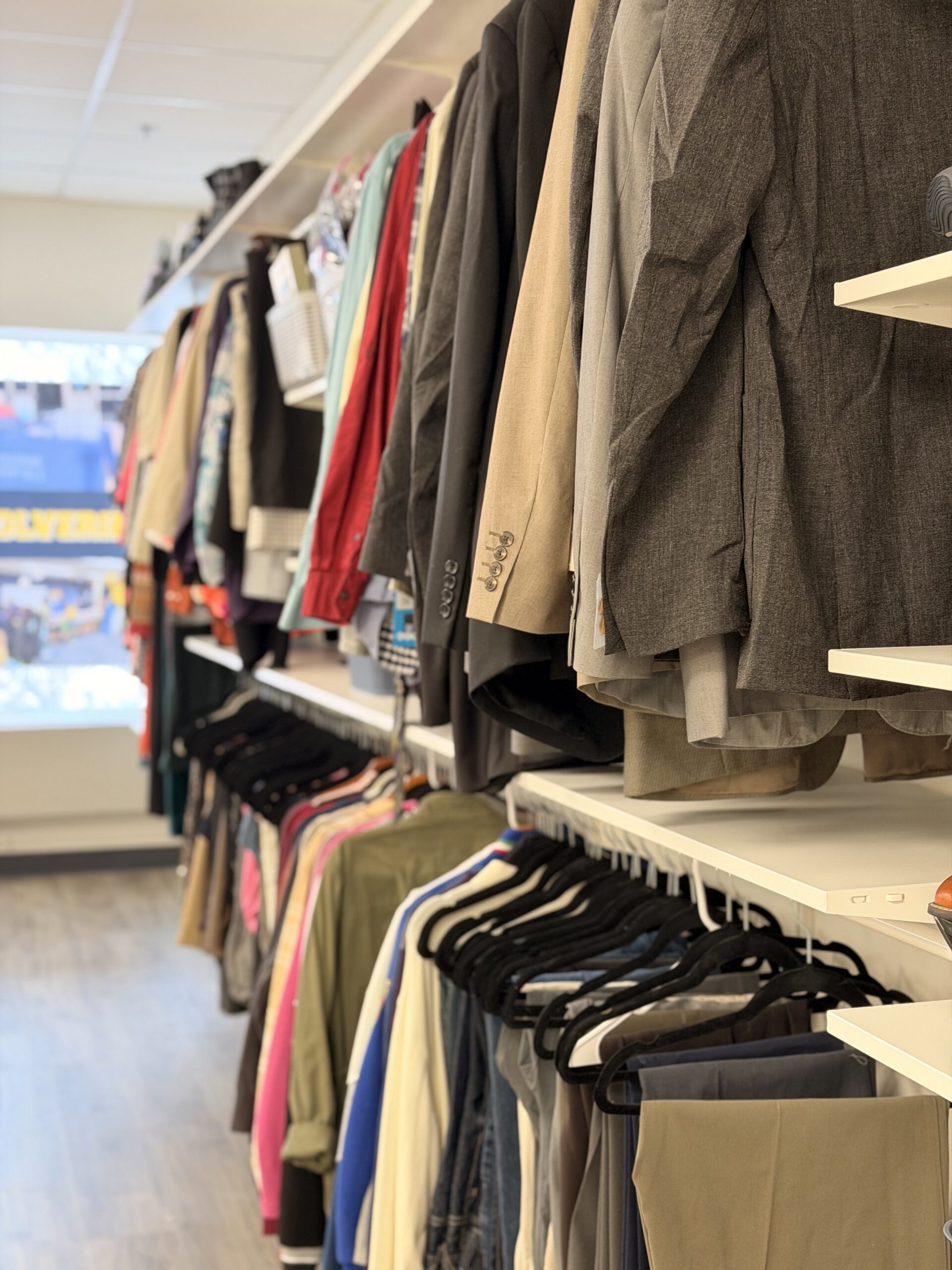 A clothing rack displaying various jackets and shirts in a retail setting.