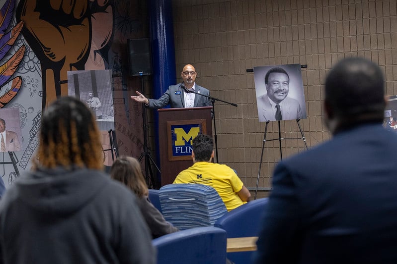 University leader speaking at a podium during a campus recognition event.