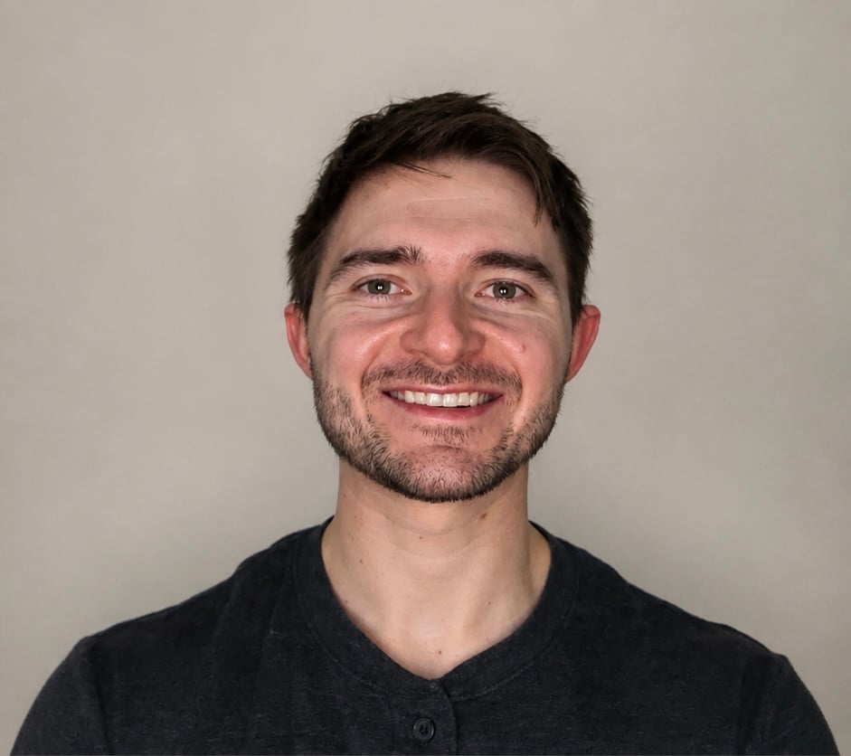 Max M. smiling at the camera against a neutral background.