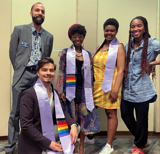 Four students at an event with David Luke.