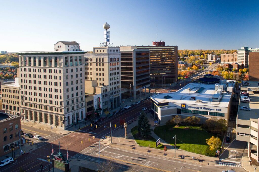 Aerial view of downtown Flint, Michigan, featuring the University of Michigan-Flint and surrounding buildings in autumn.