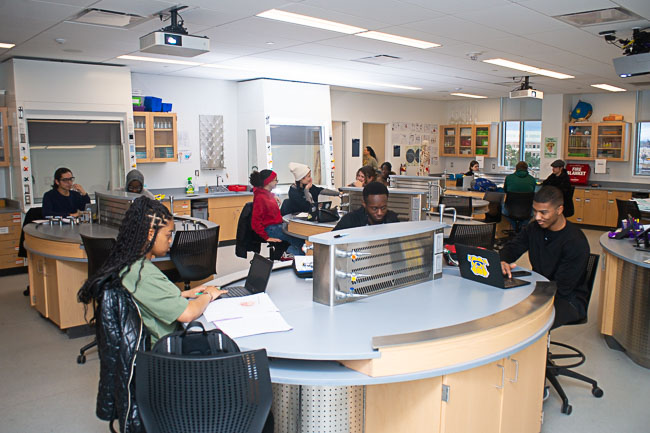 Students working at laptops in a science classroom lab at Genesee Early College.