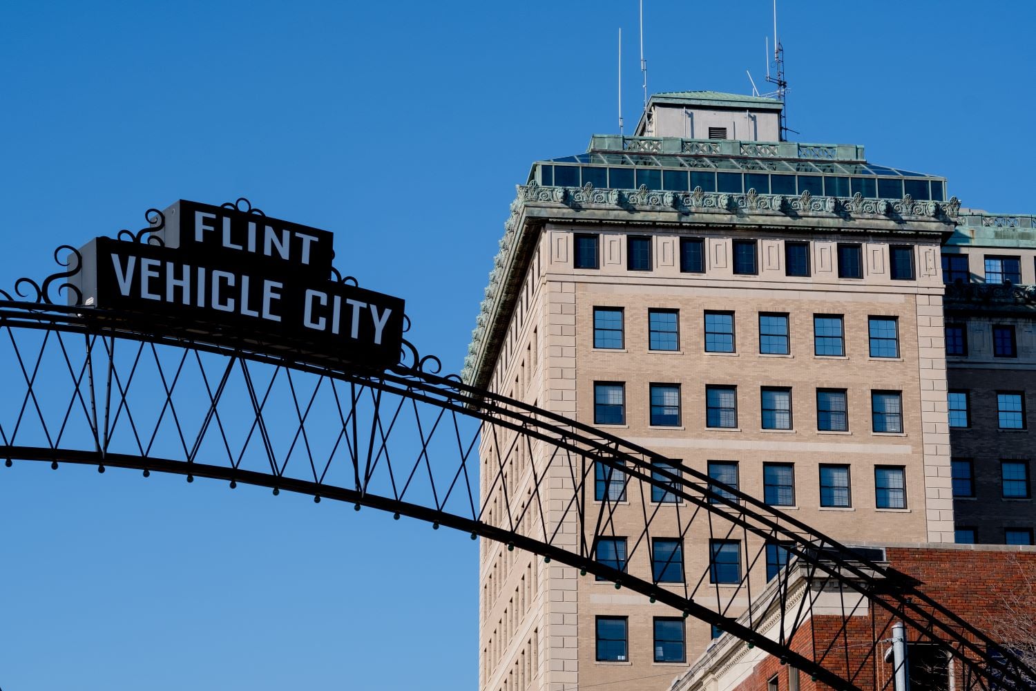 Flint Vehicle City sign with the Northbank Center building behind it