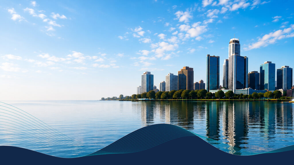 A skyline of tall buildings reflects in calm water under a clear blue sky with scattered clouds.