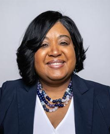 African American woman with a navy blazer and blue beaded necklace