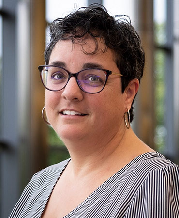 Potrait of a woman with short brown hair in a striped top