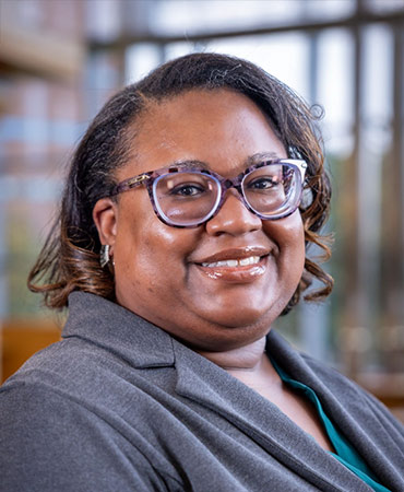 African American woman with curled hair and glasses