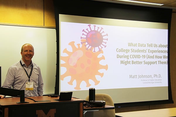 Man smiling next to his presentation