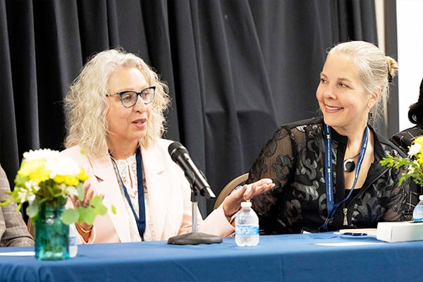 two woman talking during a presentation
