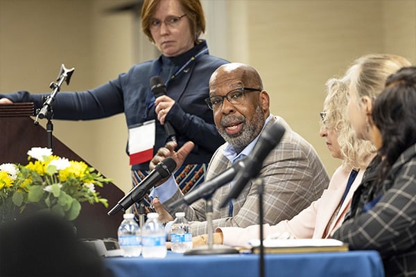 a man on a panel speaking