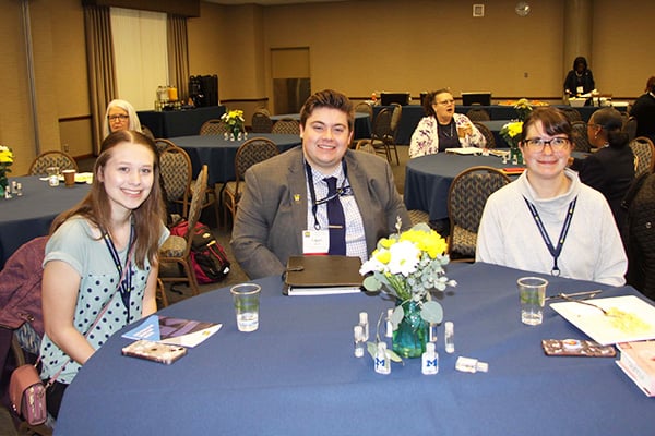 three people at a table at a conference