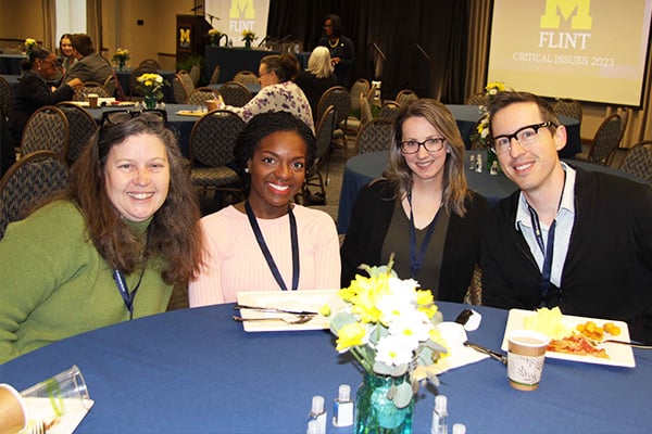 four people at a table at a conference