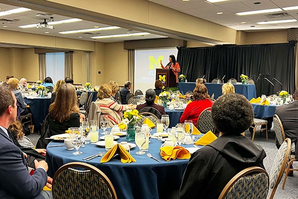 a woman presenting to a large room of attendees