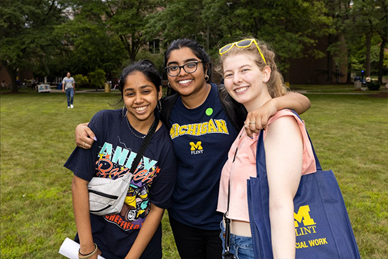 Three female students outside posing for a photo