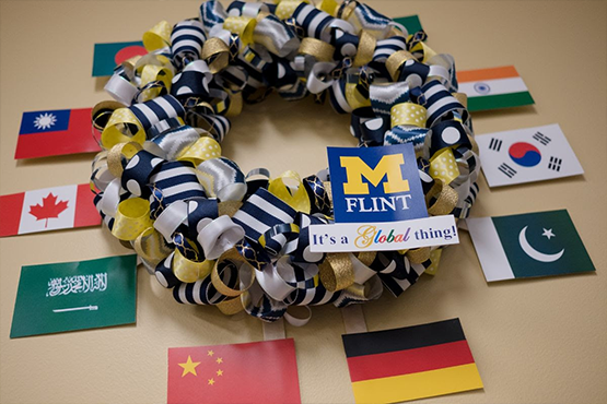 Maize and blue wreath with international flags around it