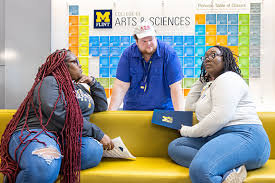 two women on a couch talked to a man behind them