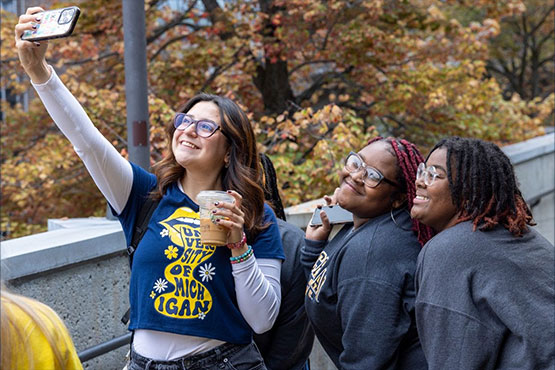 Three female students taking a selfie outside