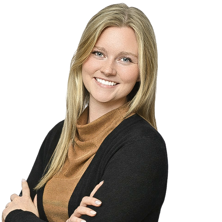 A young woman with long blonde hair smiling and posing with her arms crossed. She is wearing a black cardigan over a brown, loose-fitting turtleneck.