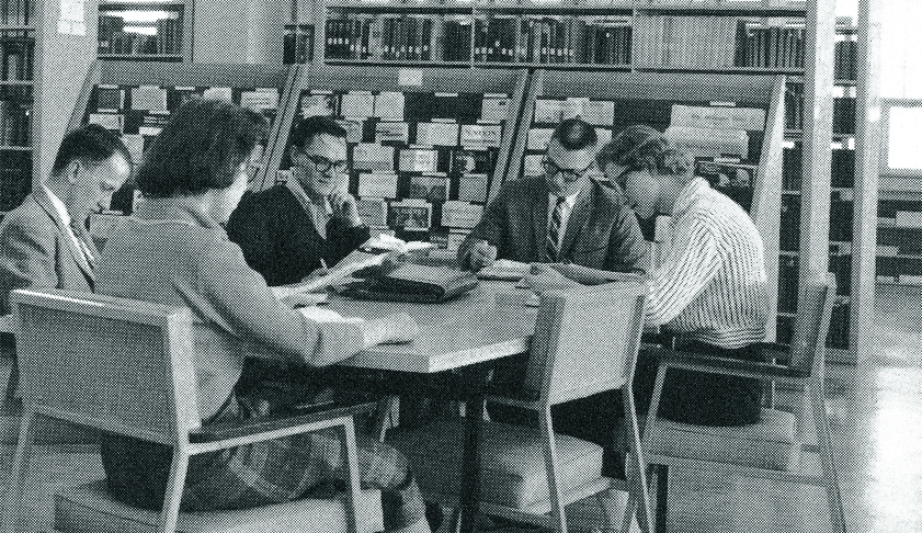 Students and staff seated around a table in the newly dedicated Mott Library.