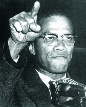 Malcolm X speaking and gesturing during his visit to campus.
