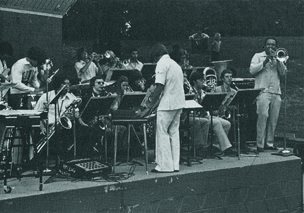 A band performing outdoors at a Music Department concert in Willson Park.
