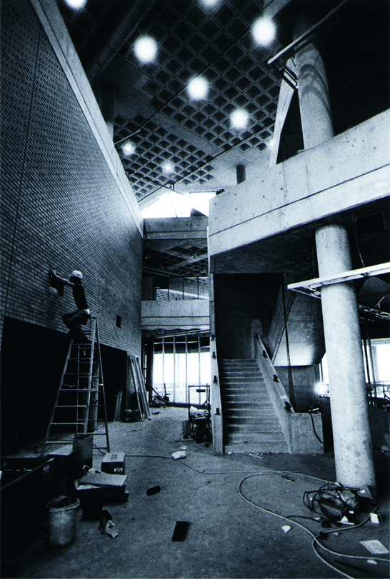 Interior of the University Center under construction, with scaffolding and stairs.