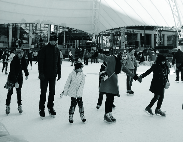 People ice skating outdoors at the UM-Flint Ice Rink.