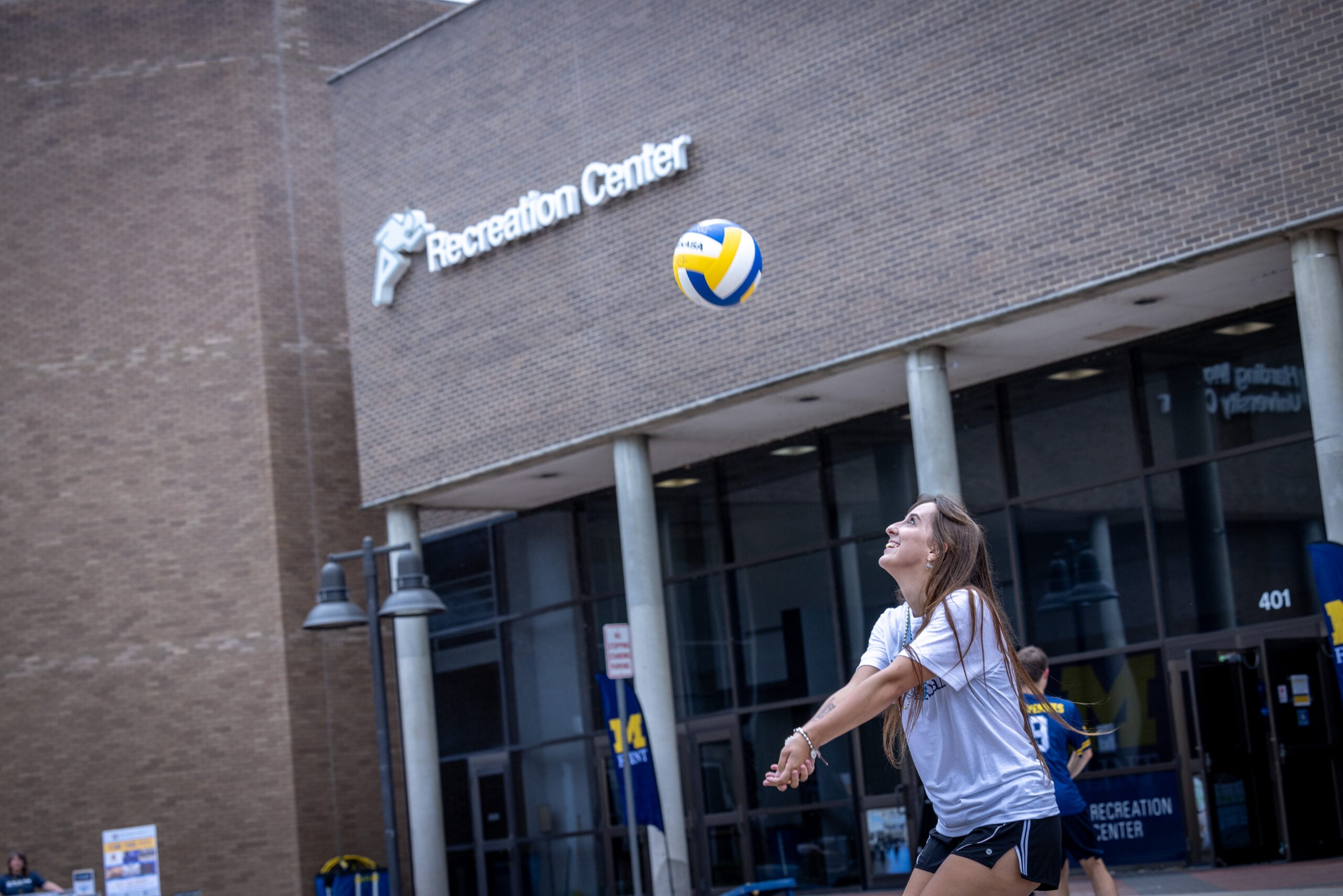 Female student hitting a volleyball outside the university's Recreation Center.
